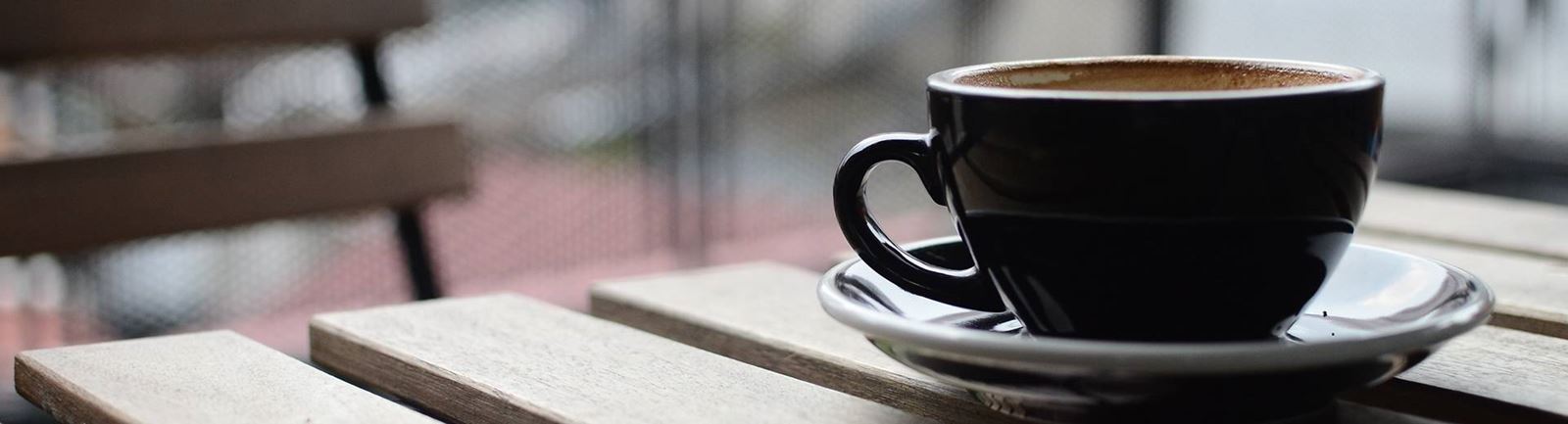En kaffekopp på ett cafébord utomhus
