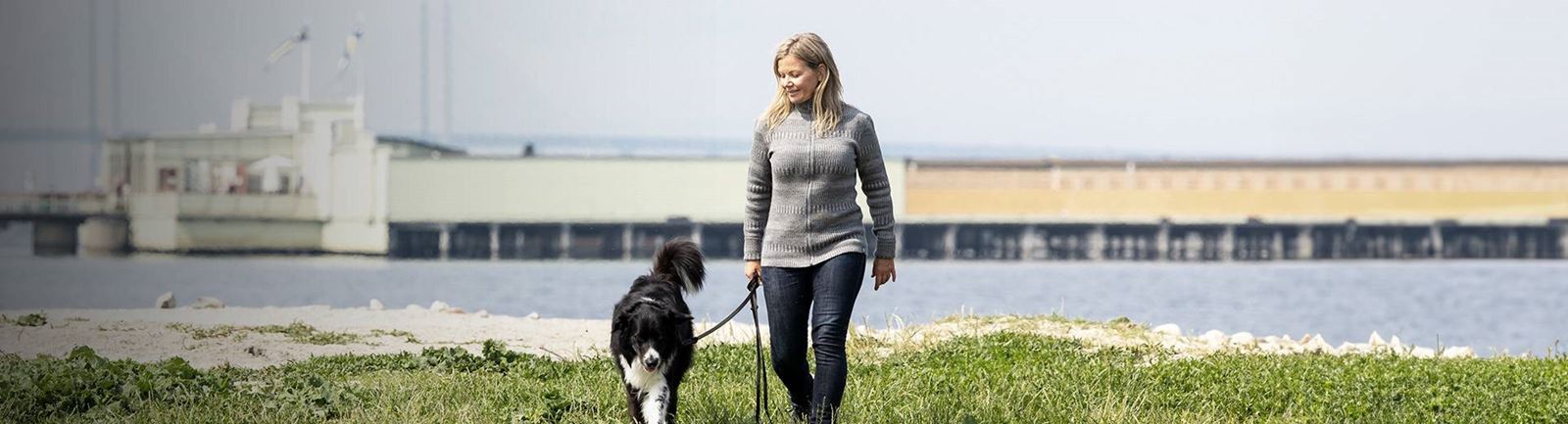 Kvinna går vid kallbadhuset på Ribersborg i Malmö med sin hund