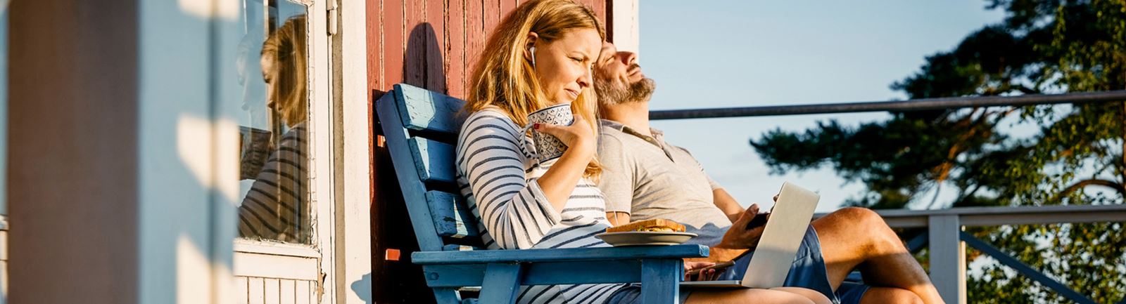 Par sitter på en terrass och njuter av solen som lyser på dem