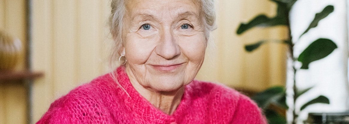 Äldre kvinna i rosa kofta